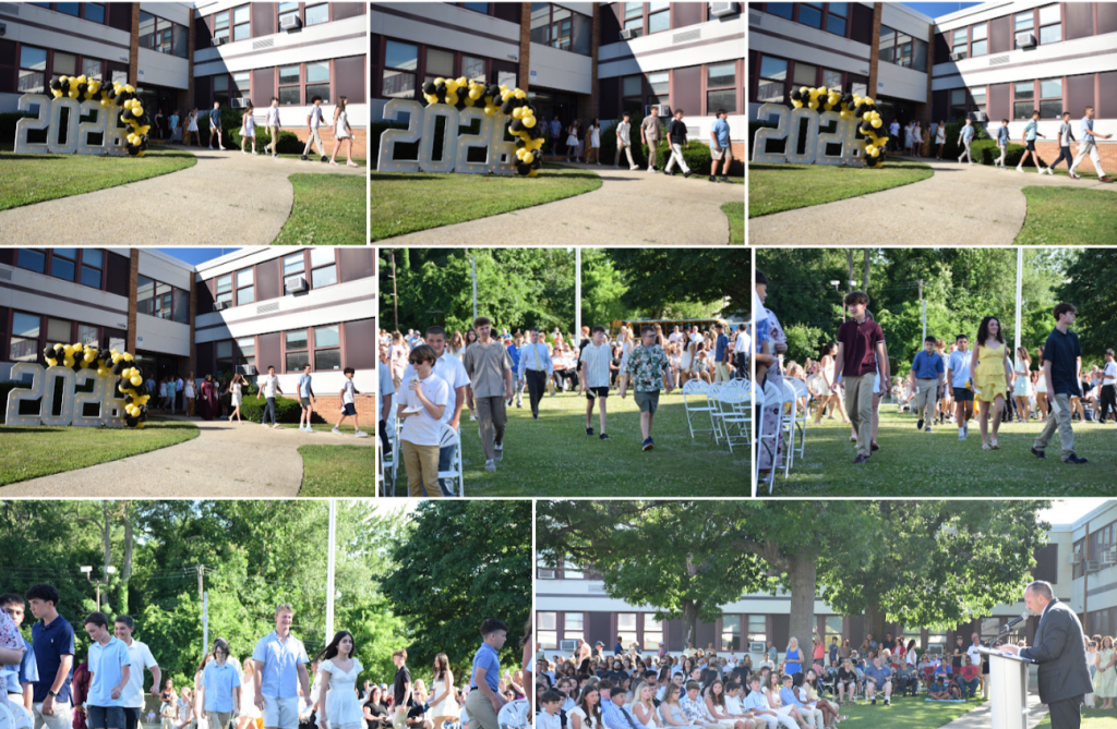 students walking in grass past large 2026 sign
